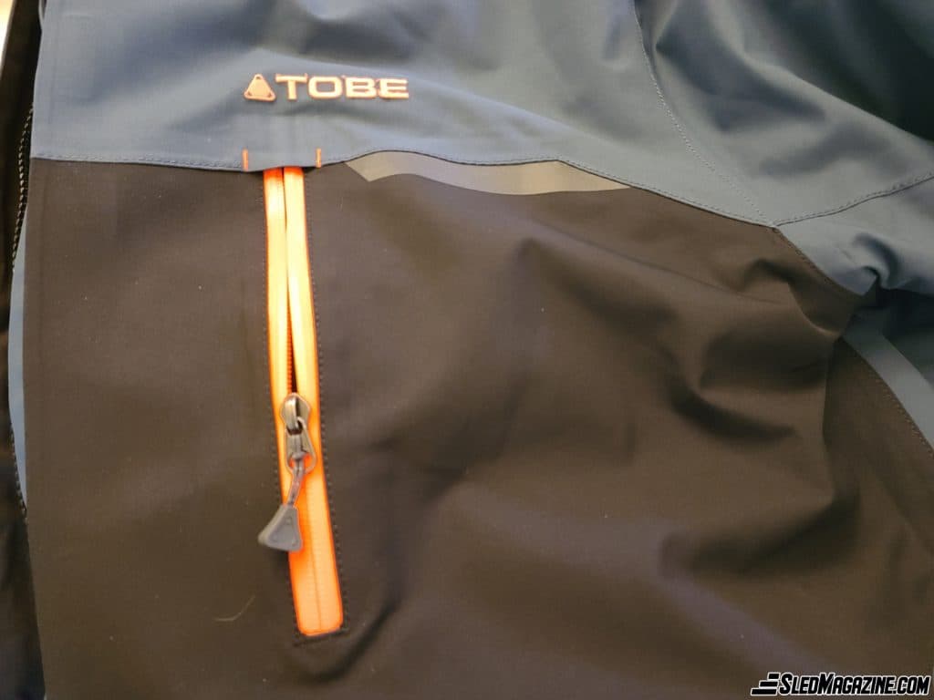 The zippers on the outside pockets are waterproof and prevent water or snow from getting inside. The chest pocket is convenient for a cell phone.