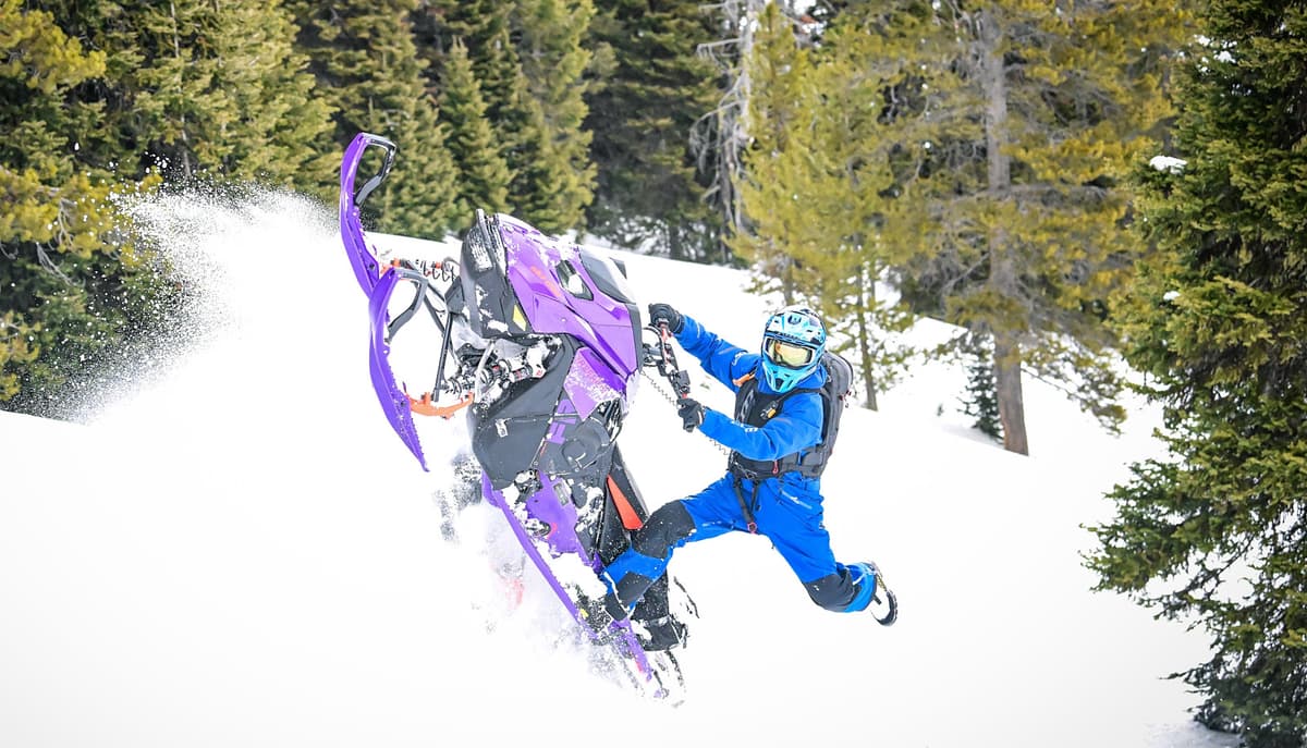 a man dressed in blue doing a manoeuvre with the Ultraviolet Ski-Doo 2027 Freeride in the snow.
