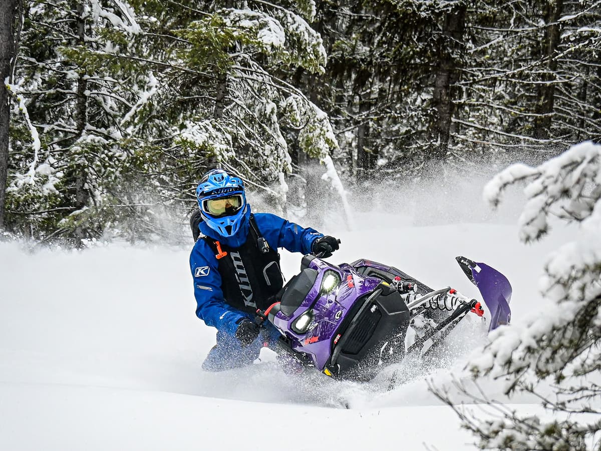 A man dressed in blue rides an Ultraviolet purple Ski-Doo 2027 Freeride in powder snow.