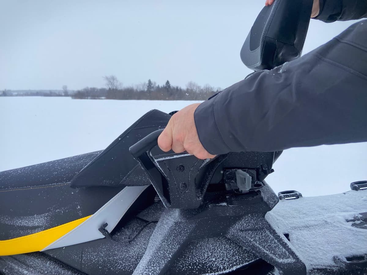 the trail linq passenger seat being installed on a snowmobile