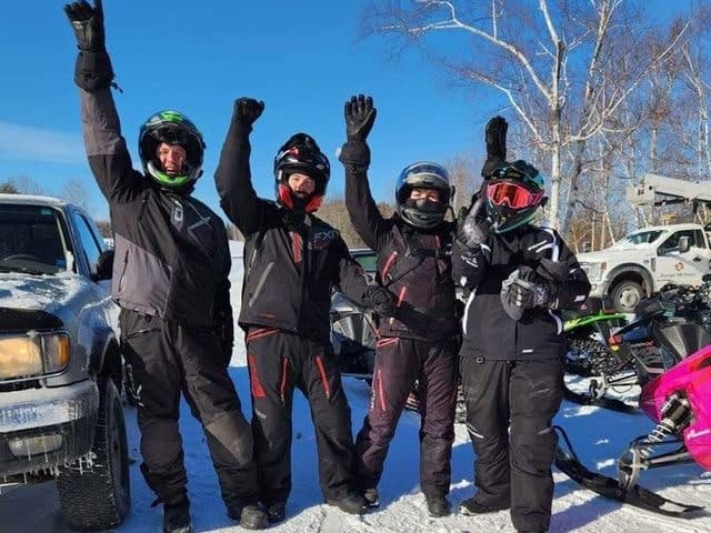 Four participants of the 1000 mile challenge with their arms in the air with joy
