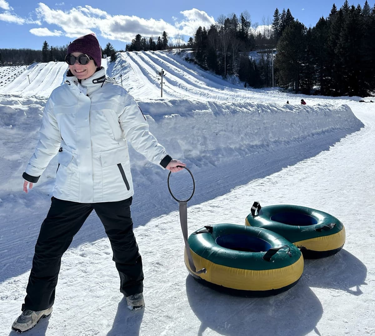 A woman wearing the typha x kanuk jacket pulling sliding tubes