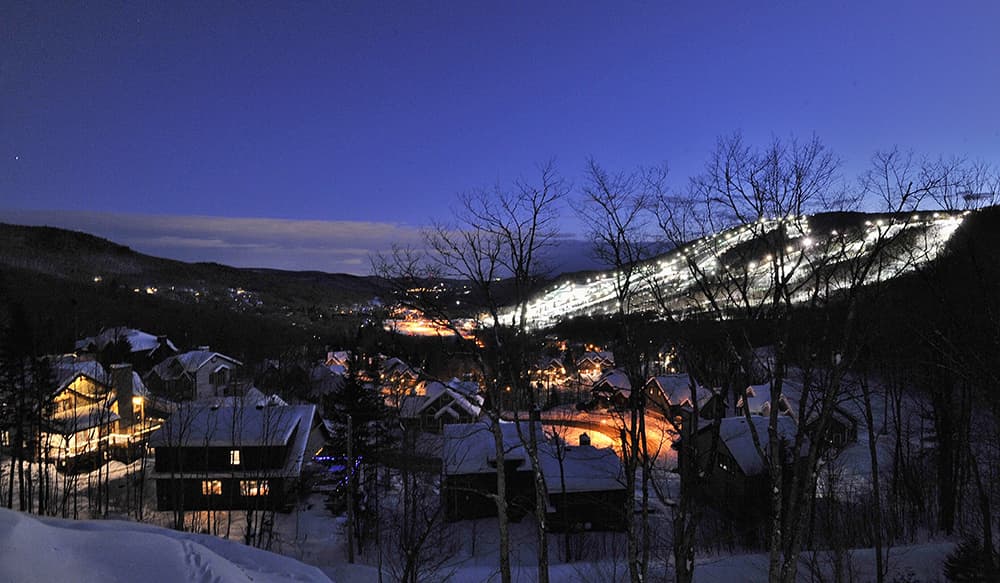 Chalets Alpins Stoneham exterior evening winter lodge