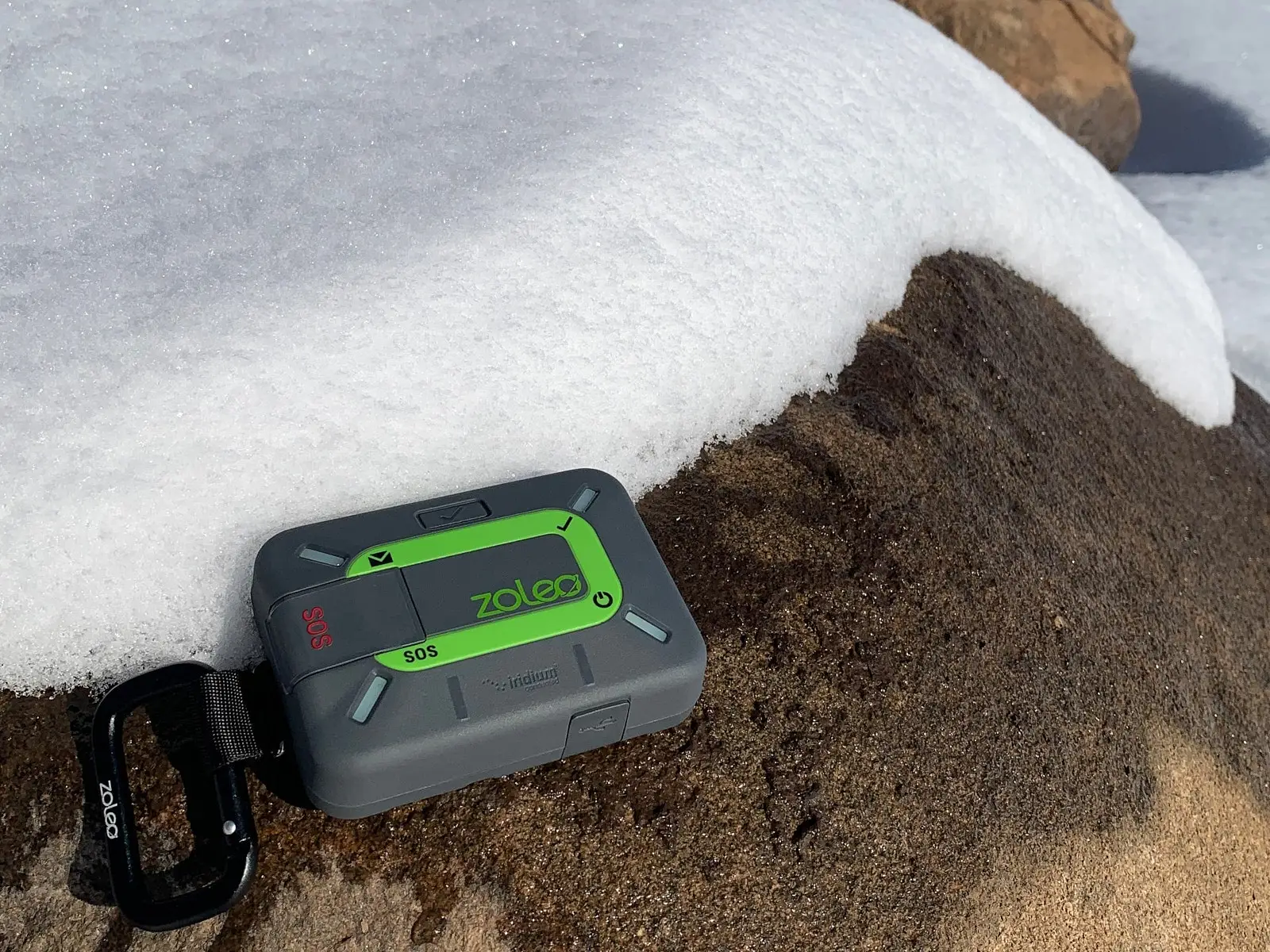 Le communicateur ZOLEO déposé sur une roche recouverte de neige